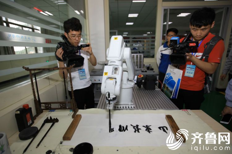 记者参观山东技师学院工业机器人用毛笔写字